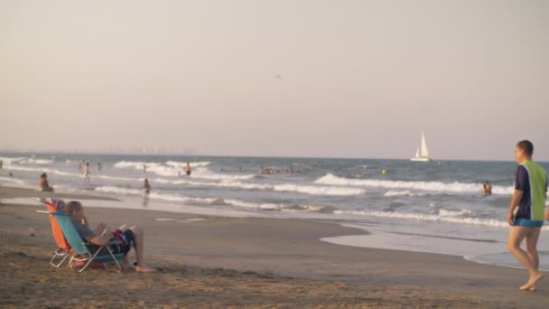 Personas bañándose en el mar y relajándose en la playa en Valencia, España — Vídeos de Stock