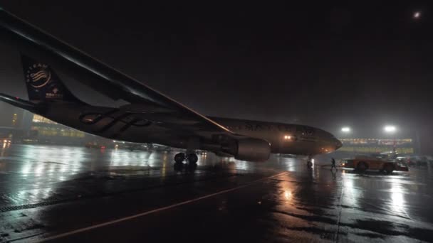 Empurramento de avião no aeroporto, vista na noite chuvosa — Vídeo de Stock