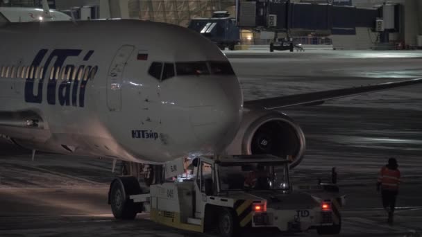 Avión Utair retrocediendo. Vista nocturna en el aeropuerto de Vnukovo en Moscú, Rusia — Vídeo de stock