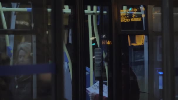 야간 도시에서 버스 정류장을 떠나는 버스 — 비디오