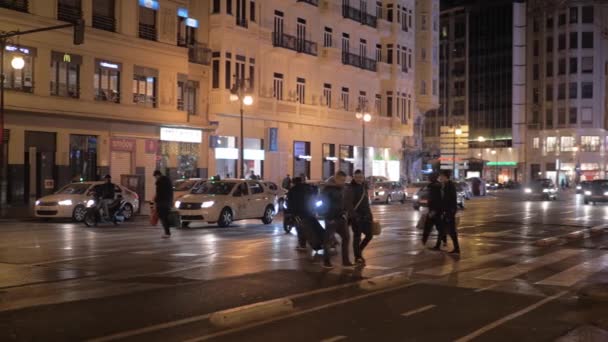 Vista noturna de pessoas na passarela em Carrer de Xativa. Valência, Espanha — Vídeo de Stock