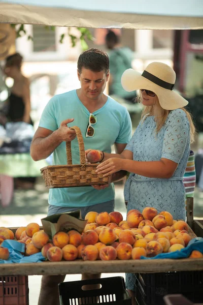 Paar bekommt Pfirsiche auf dem Markt — Stockfoto