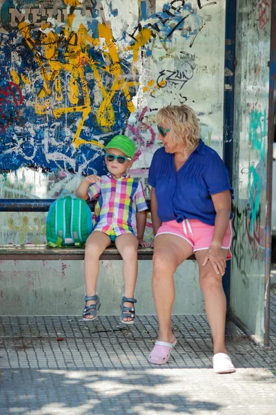 Multicolor beach people at a bus stop — Stock Photo, Image