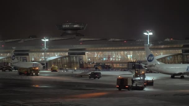 Kış gecesi Vnukovo Havaalanı, Moskova. Kar saban kamyonları asfalt temizleme — Stok video