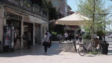 Lido adasında yürüyen insanlar ve açık hava kafe ile Sokak, İtalya