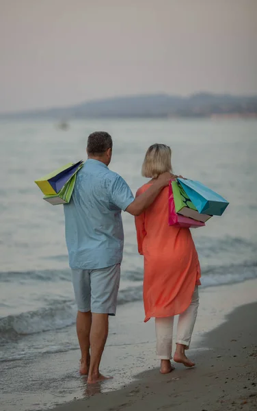 Una pareja de mediana edad caminando por la costa del mar descalza —  Fotos de Stock