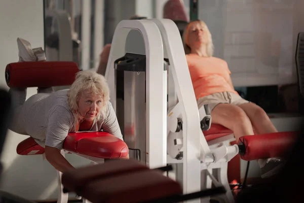 Two middle aged women working out in a gym — Stock Photo, Image