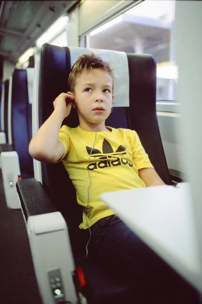 Enfant avec écouteurs en train — Photo