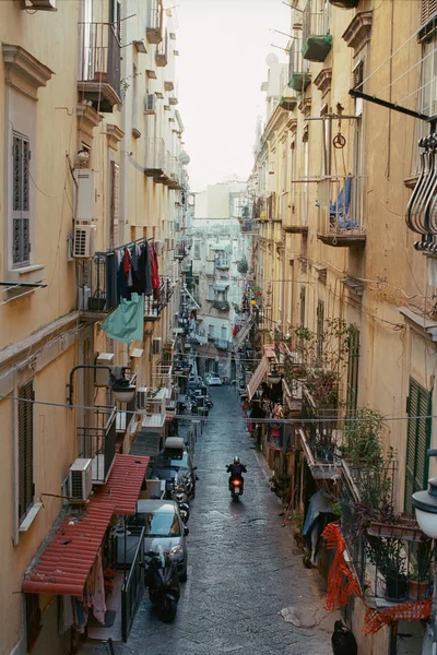 Alleyway com moto dirigindo entre casas antigas em Nápoles, Itália — Fotografia de Stock