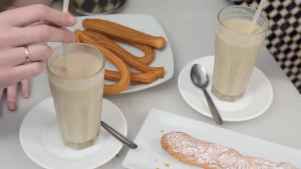 バレンシアのカフェ、スペインでファルトンとチュロスを持つホルチャタ — ストック動画