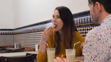 Erkek ve kadın fartonlar ve churros ile horchata içme