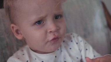 Elinde turuncu bir tablet ile adil saçlı kız bebek