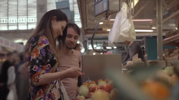 Egy-két vásárol gyümölcsöt egy helyi piacon — Stock videók