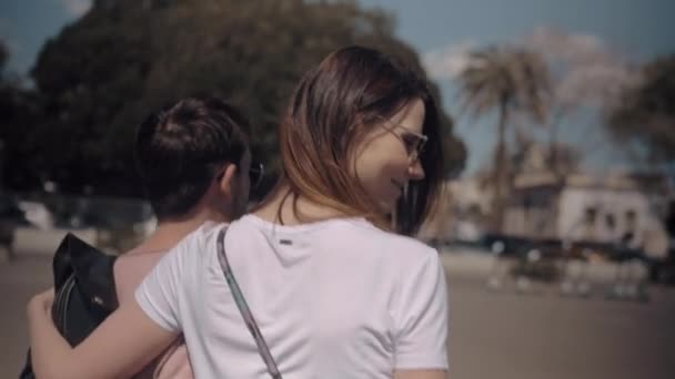 Una vista trasera de una pareja caminando en un día soleado — Vídeo de stock