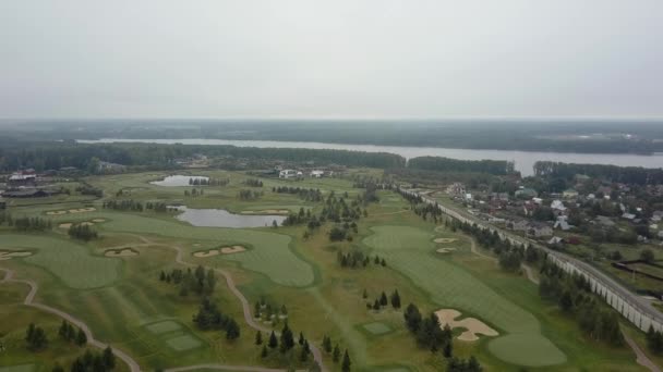 Luchtfoto van golfvelden en Township nabij de rivier — Stockvideo