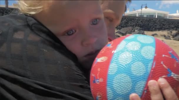 Uma menina com sua mãe em uma praia — Vídeo de Stock