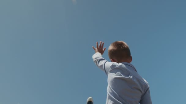 Niño saludando la mano al avión sobre la cabeza — Vídeos de Stock