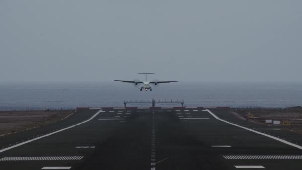 Flygplan kommer in för landning på landningsbanan med utsikt över havet — Stockvideo
