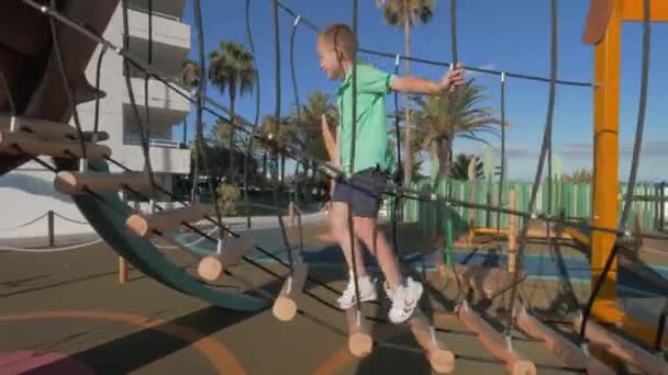 Активный отдых и развлечения для детей на детской площадке — стоковое видео