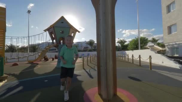 Garçon courant dans le labyrinthe de l'aire de jeux — Video