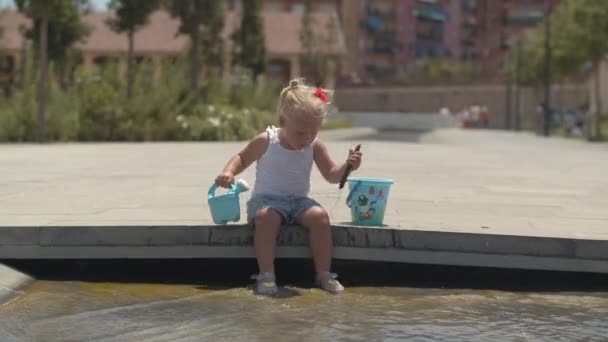 Baby meisje spelen in fontein op warme dag — Stockvideo