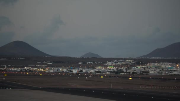 Ein Flugzeug hebt von der Landebahn gegen die Abendberge ab — Stockvideo