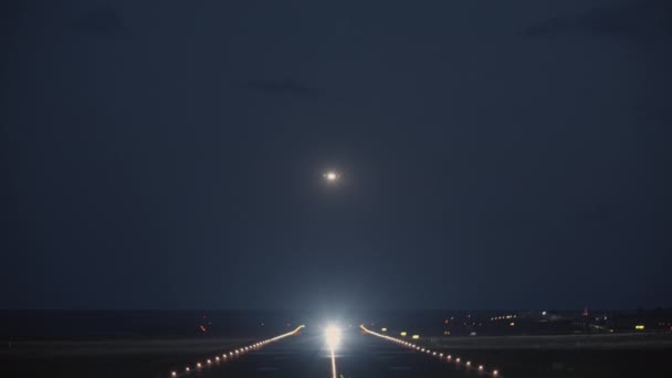 Ночной вид на взлетно-посадочную полосу с взлетающим самолетом — стоковое видео