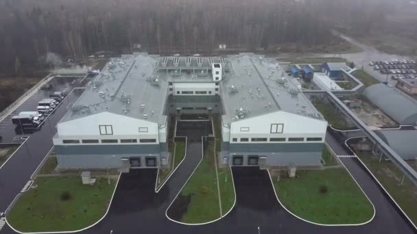 Een luchtfoto van twee industriële gebouwen in een sneeuwval — Stockvideo