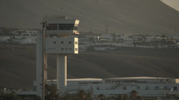 Dağ yamaçlarına karşı akşam güneşi ışınları bir gözlem kulesi — Stok video