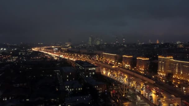 Una vista aérea de una ciudad nocturna con una carretera concurrida — Vídeo de stock