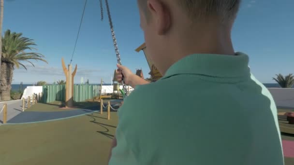 Pojke tar kabel rida på lekplatsen — Stockvideo