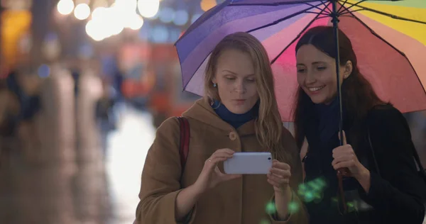 Women making funny selfie in evening rainy city — Stock Photo, Image