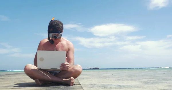 Man in snorkel using pad on pier — Stock Photo, Image