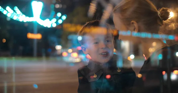 Lycklig mor och barn pratar i natten stad — Stockfoto