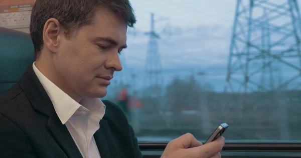 Homme d'affaires utilisant un téléphone intelligent pendant le voyage en train — Photo