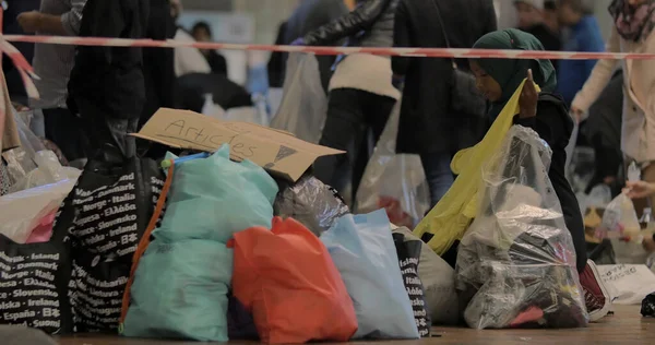Сирийский беженец выбирает одежду для детей в пункте сбора пожертвований на железнодорожной станции Копенгагена — стоковое фото