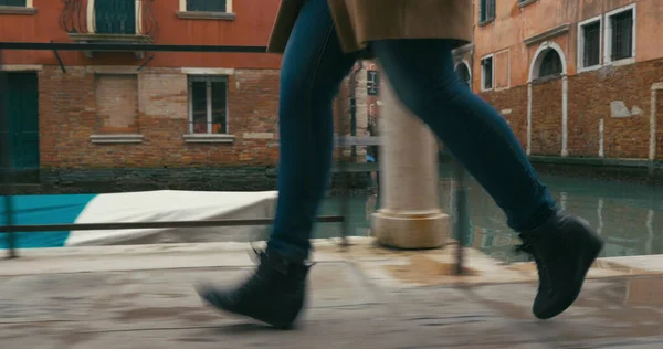 Woman in haste moving along Venetian canal