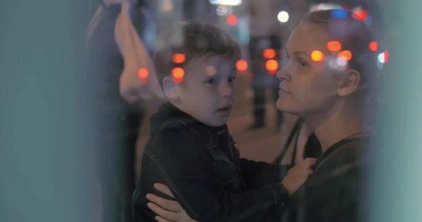 Trött pojke ger kram till mamma vid busshållplatsen — Stockfoto