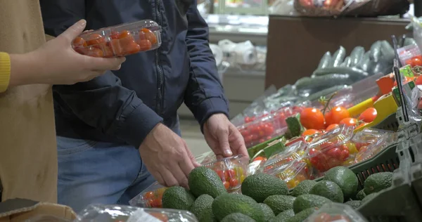 Klanten die tomaten kiezen in de supermarkt — Stockfoto
