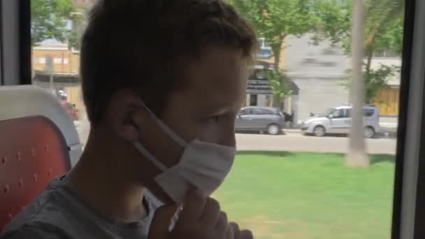 Hladový dítě v masce obličeje jíst lupínky v autobuse — Stock video