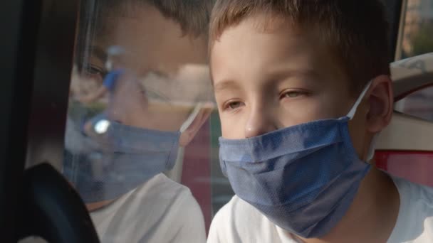 Cansado de viver com máscara. Criança no ônibus da cidade — Vídeo de Stock