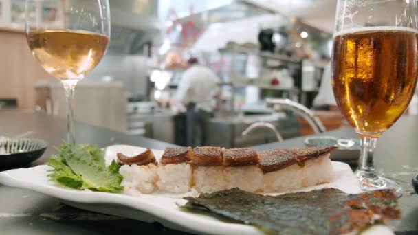 Prato de sushi com bebidas alcoólicas no restaurante — Vídeo de Stock