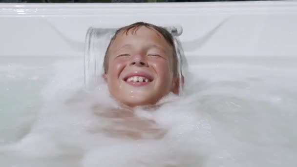 Hydromasaż jest ekscytujący. Dziecko bawiące się w wannie spa — Wideo stockowe