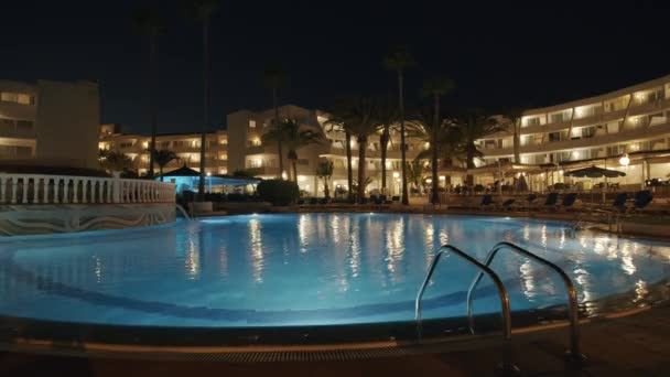 Resort scen med en pool på natten — Stockvideo