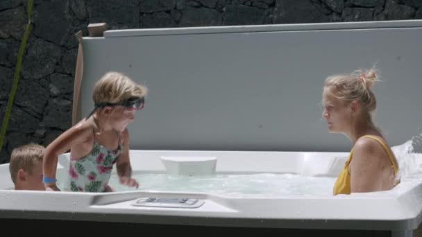 Mãe com crianças aproveitando o tempo na banheira de hidromassagem ao ar livre — Vídeo de Stock