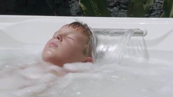 Мальчик отдыхает в джакузи — стоковое видео