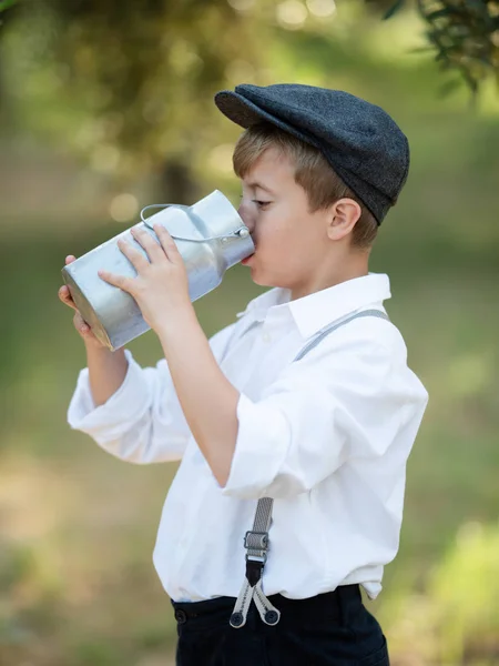 Może mały chłopiec napoje mleczne z aluminium. — Zdjęcie stockowe