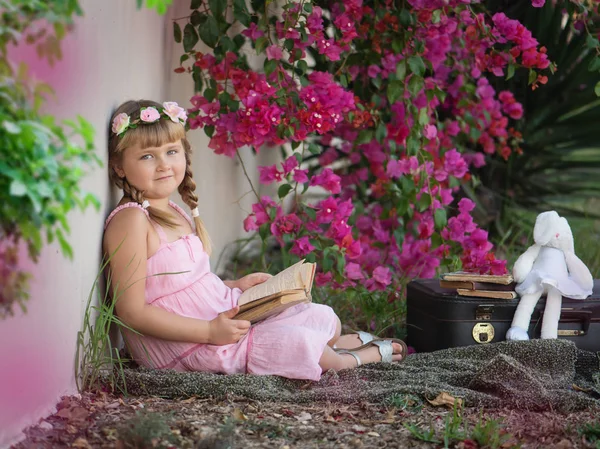 Klein meisje met een boek in het park — Stockfoto