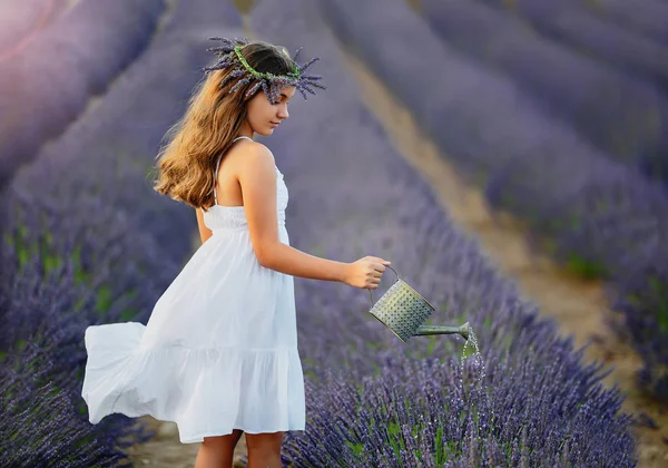 Schönes Mädchen mit einem Kranz aus Lavendelblüten auf dem Kopf — Stockfoto