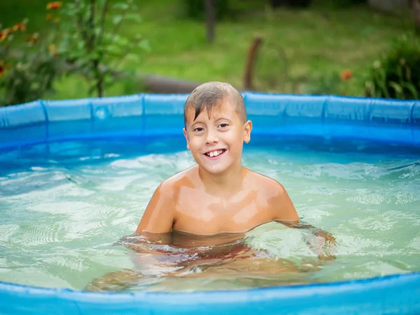 Cute blond boy bathing in a small pool — Stock Photo, Image